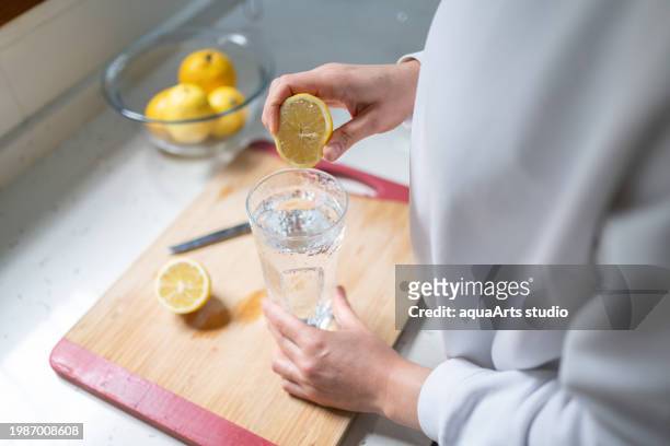 woman squeezing out juice of lemon - drinking lemonade stock pictures, royalty-free photos & images
