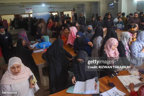 Pakistan's women wait in a queue to cast their ballots to vote during national elections, at a polling station in Karachi on February 8, 2024....