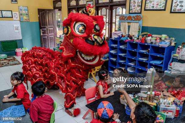 Barongsai" Lion Dance entertains students inside a classroom at Widiatmika Kindergarten in Jimbaran, Badung, Bali, Indonesia, marking the celebration...