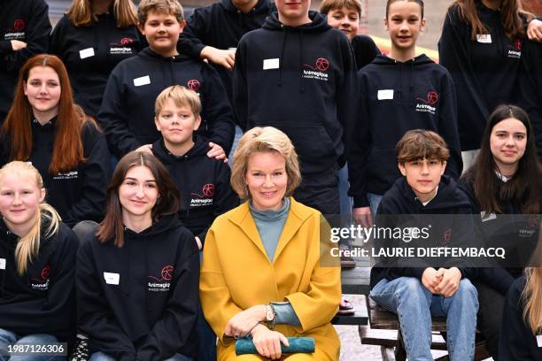Queen Mathilde of Belgium sits with children during a royal visit to the Mik'Ados project of organisation AniMagique, in Villers-la-Ville on February...