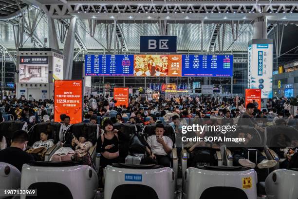 People wait to board trains at Guangzhou South Train Station ahead of the Spring Festival.