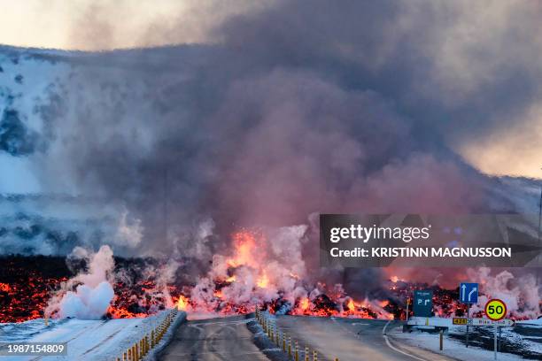 Molten lava is seen overflowing the road leading to the famous tourist destination "Blue Lagoon" near Grindavik, western Iceland on February 8, 2023....