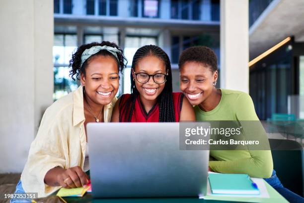 african american student friends using a laptop to do homework together at the university campus, working on a school project. - black lives matter children stock pictures, royalty-free photos & images