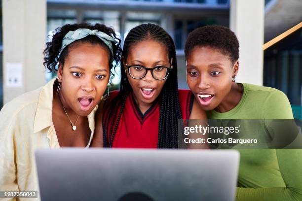 three black women stare in surprise at a laptop computer. - black lives matter children stock pictures, royalty-free photos & images