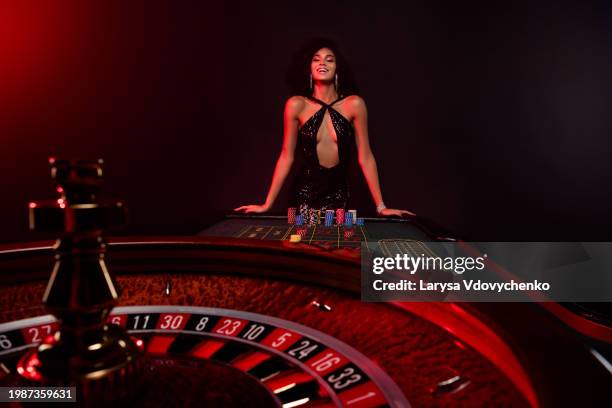 photo of of happy addicted lady all in poker look excited rotating fortune wheel wait for incredible jackpot victory - roleta, jogos - fotografias e filmes do acervo