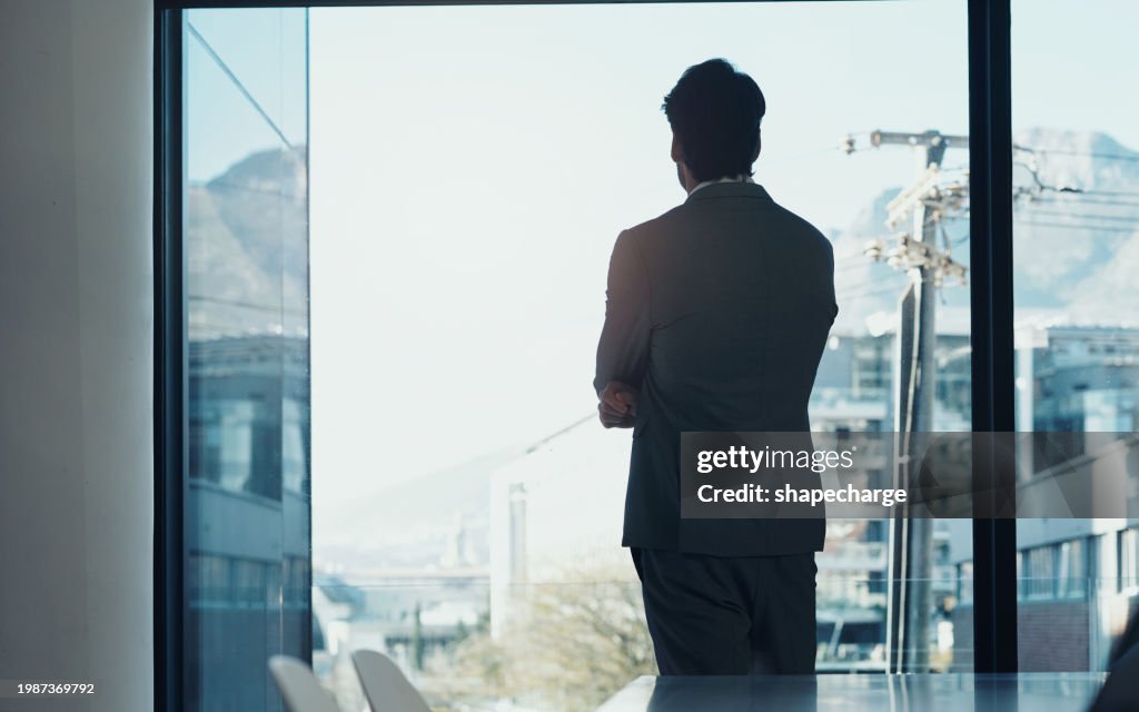 Window, thinking and development of business man in boardroom of office for future, planning or vision. Glass, corporate or professional with back of employee looking at city, construction and sky