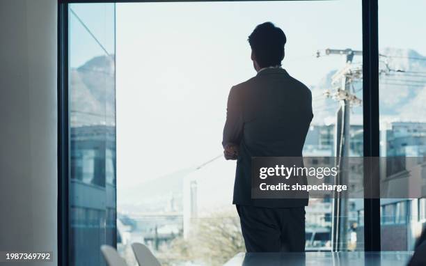 window, thinking and development of business man in boardroom of office for future, planning or vision. glass, corporate or professional with back of employee looking at city, construction and sky - back stock pictures, royalty-free photos & images