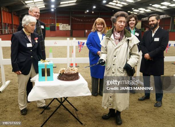 Britain's Princess Anne, Princess Royal prepares to cut a cake suring a visit to Wormwood Scrubs Pony Centre, in London, on February 8, 2024 to mark...