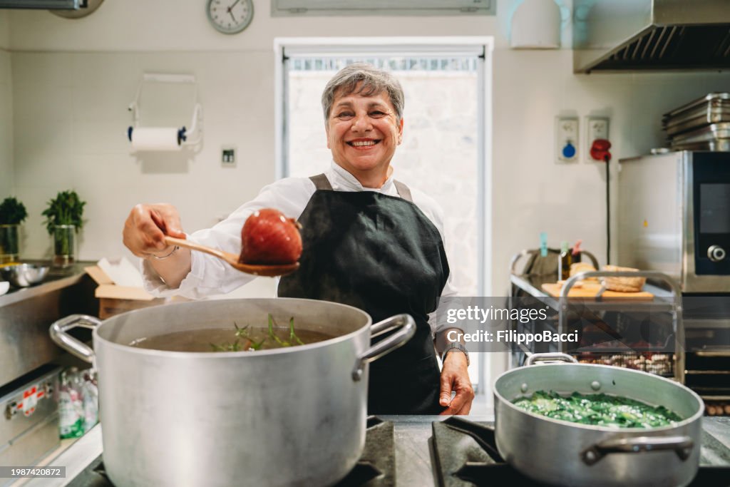 Portrait of a chef while she's preparing a vegetable soup before dinner service