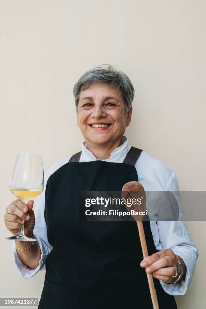 retrato de una chef con uniforme contra una pared - cuchara-de-madera fotografías e imágenes de stock