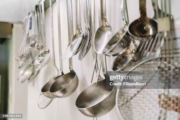 hanging ladles in a professional restaurant's kitchen - kökstillbehör bildbanksfoton och bilder