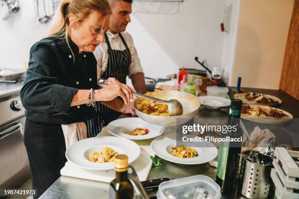 chefs are plating a first course with pasta and seafood - paccheri bildbanksfoton och bilder