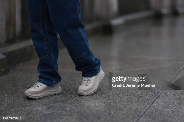 Jeanna Krichel seen wearing blue denim / jeans cargo pants and Hoka Tor Summit oat milk / oxford tan sneakers, on January 26, 2024 in Berlin, Germany.
