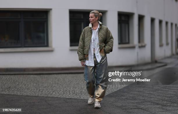 Jeanna Krichel seen wearing gold earrings and necklace, khaki green padded quilted jacket, white cotton blue flower pattern buttoned blouse shirt,...