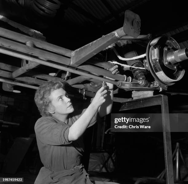 Car manufacturer Daphne Arnott fixing the brake cable on the chassis of the sports car she designed and helped to build at Arnott's Garages in...
