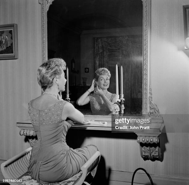 American actress Yolande Donlan sitting in front of a mirror at her home in Montagu Square, London, November 1955.