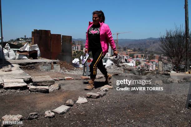 Brenda Bustos walks past the site of his house burned by forest fires in the Poblacion Monte Sinai neighborhood in Viña Del Mar, Chile, on February...