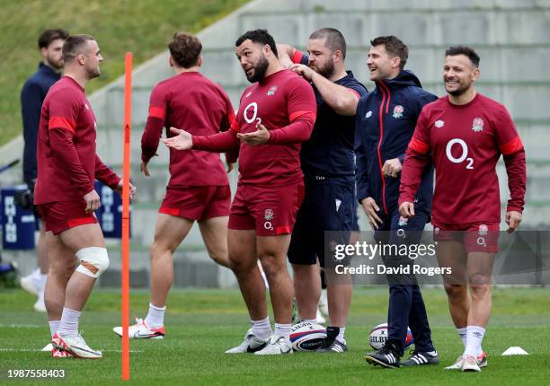 Ben Earl speaks with Ellis Genge of England as Tom Harrison, Scrum Coach of England, adjusts his statistics tracking device during the England Rugby...