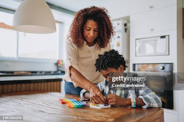 mother playing with autistic son - black autistic child stock pictures, royalty-free photos & images