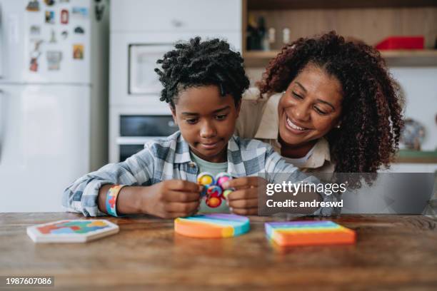 madre jugando con su hijo autista - neurodiversidad fotografías e imágenes de stock
