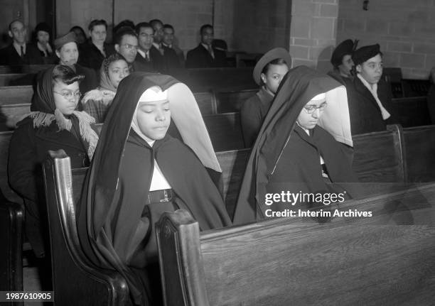 African American Catholic nuns sit in prayer during a church service or mass at an African American church in the South Side neighborhood of Chicago,...