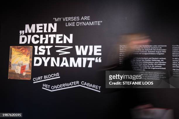 Visitors pass by a wall with the lettering "My verses are like dynamite" during a preview of the exhibition Curt Bloch's Het Onderwater Cabaret at...