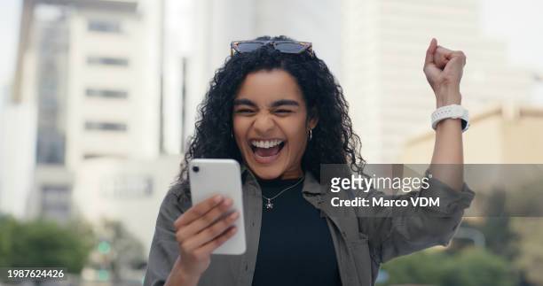 woman, smartphone and celebration for win in city, online competition and discount or promotion. female person, fist pump and excited for opportunity on mobile app, lottery prize and virtual giveaway - incentive stock pictures, royalty-free photos & images