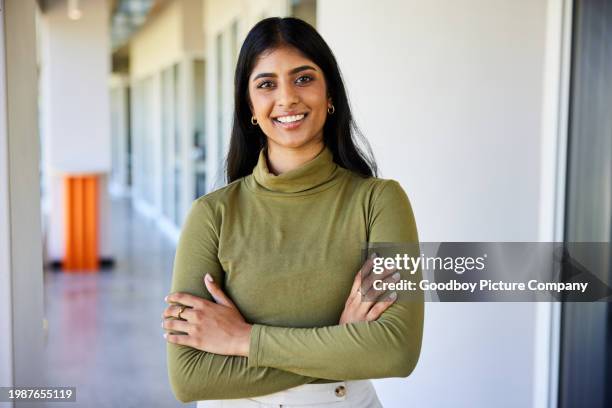 joven empresaria sonriente parada en el pasillo de una oficina - vestimenta casual fotografías e imágenes de stock