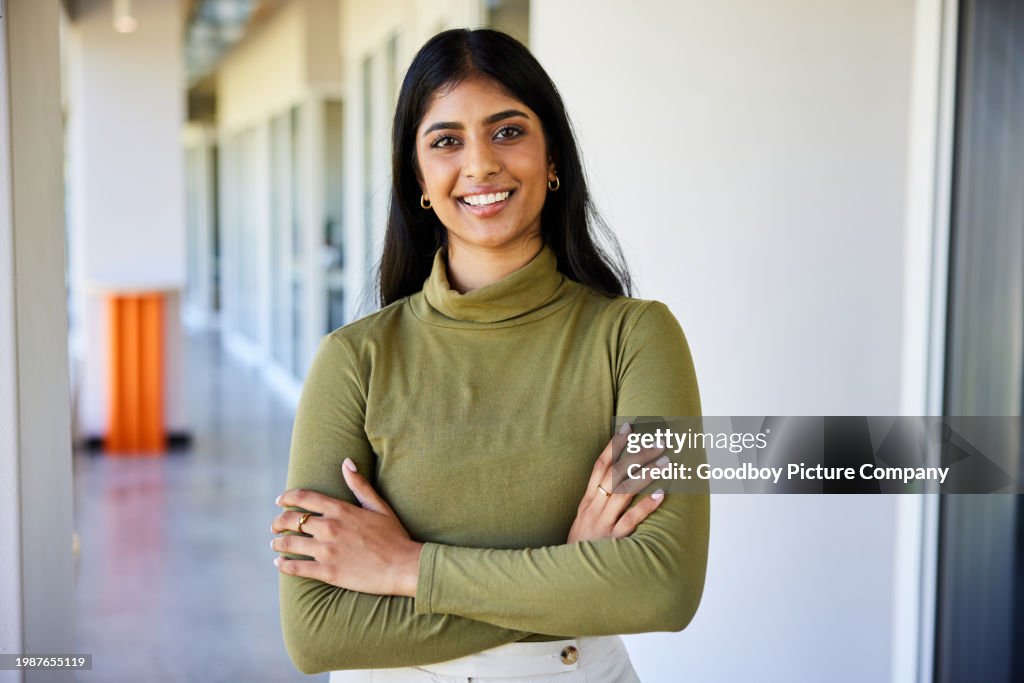 Smiling young businesswoman standing in the corridor of an office