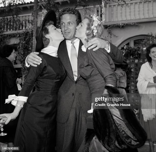 American actress Jeanne Crain, wearing a black-and-white outfit with a wide-brim black hat, American actor Robert Stack, who wears a suit and tie,...