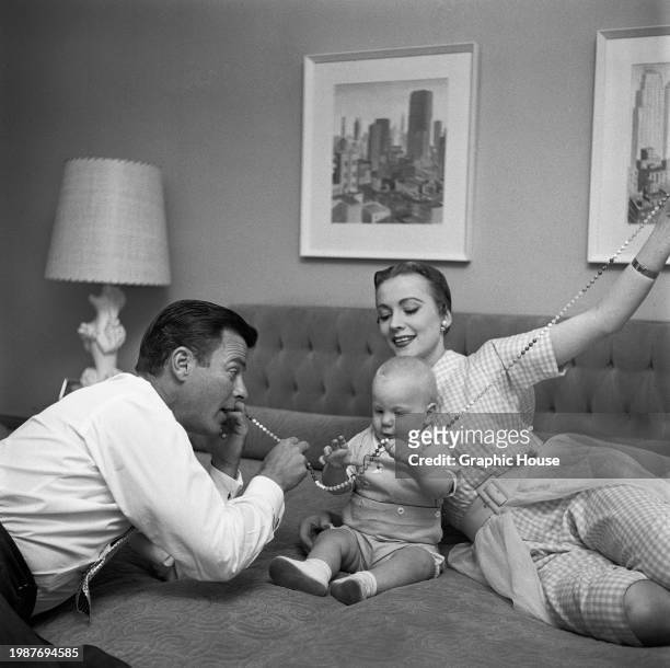 American actor Robert Sterling and his wife, American actress and singer Anne Jeffreys playing with their son, Jeffrey, with all three holding onto a...