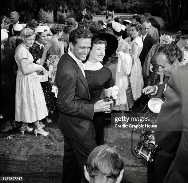 American actor Robert Stack, wearing a suit and tie, and American actress Jeanne Crain, who wears a black-and-white outfit with a wide-brim black...