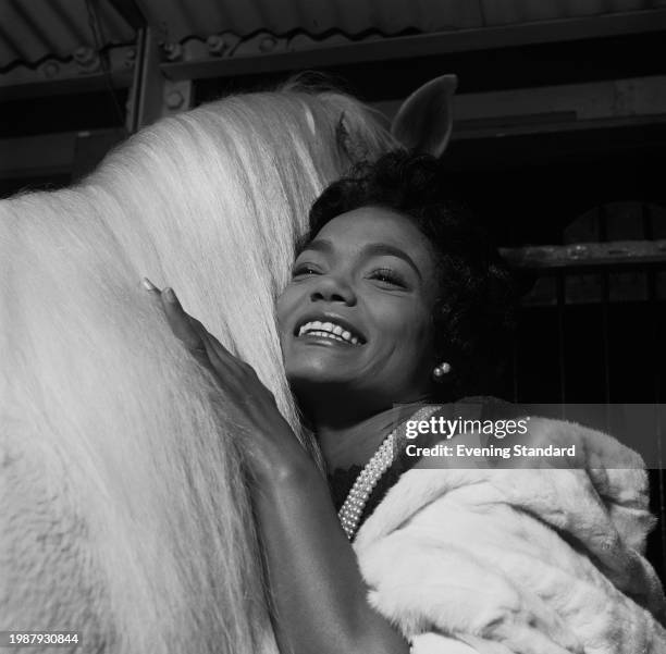 American singer and actress Eartha Kitt embracing a horse, January 12th 1956.