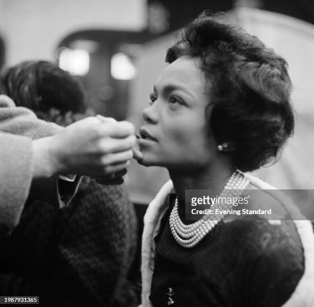 American singer and actress Eartha Kitt has her makeup applied by an assistant, January 12th 1956.