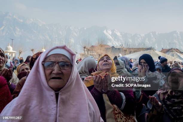 Muslim women raise their hands in prayers as the head cleric displays the holy relic believed to be a hair from the beard of Prophet Muhammad on the...