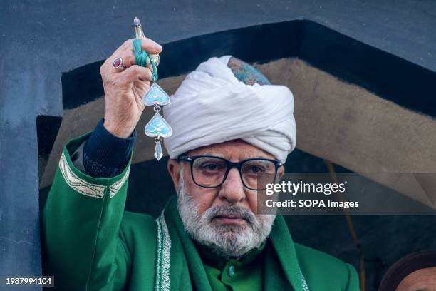 Muslim head cleric displays the holy relic believed to be a hair from the beard of Prophet Muhammad on the occasion of Lailat-al-Meraj or...