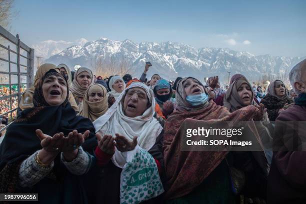 Muslim women raise their hands in prayers as the head cleric displays the holy relic believed to be a hair from the beard of Prophet Muhammad on the...
