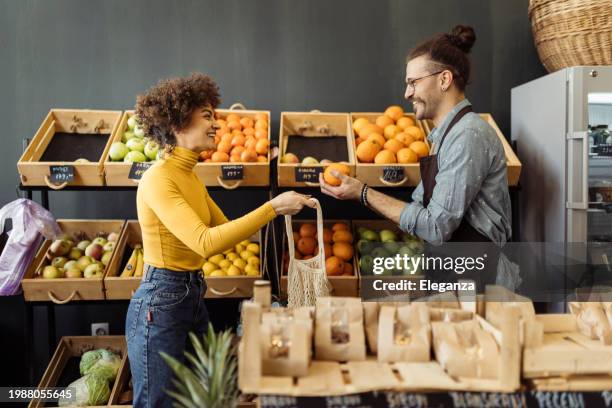 employee of a bio grocery shop helping a customer - apple products stock pictures, royalty-free photos & images