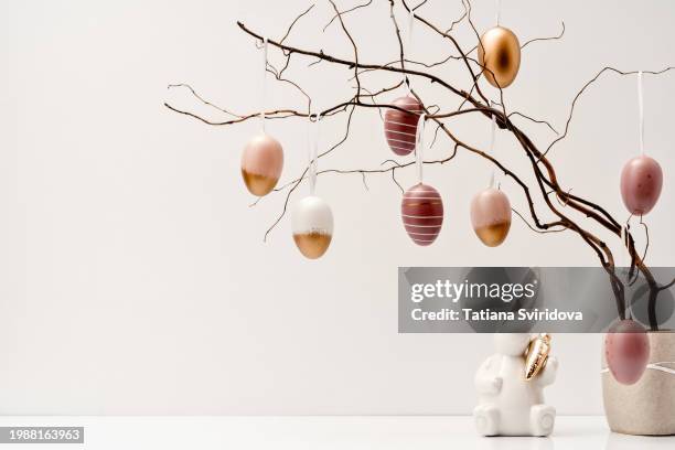 pastel golden easter eggs on branches and ceramic easter bunny - paint branch stock pictures, royalty-free photos & images