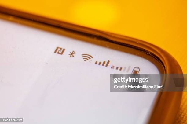 close-up of a smartphone top display symbols: bluetooth, wifi, network, battery - comunicação por campo de proximidade - fotografias e filmes do acervo