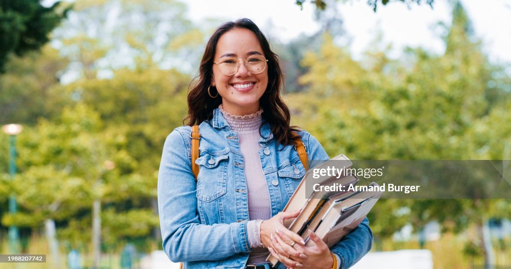 Mulher, estudante universitária e livros em retrato, ao ar livre e orgulho pelo aprendizado, conhecimento ou feliz no parque. Menina, pessoa japonesa e sorriso para bolsa de estudos, educação e estudar no campus universitário