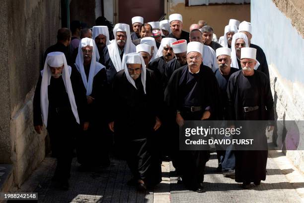 Druze clerics and relatives of Manal Azam walk to attend her funeral in the northern Israeli village of Mghar 05 August 2006 after she was killed...