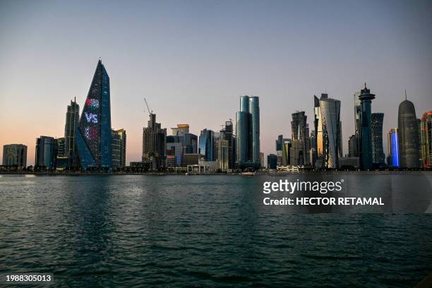 Traditional Qatari Dhow boats are seen in front of Doha's skyline at the Corniche promenade in Doha on February 8, 2024.