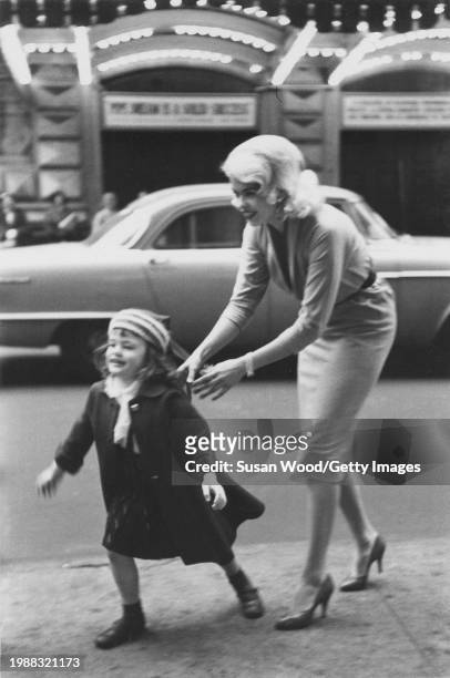 American actress Jayne Mansfield with her daughter, future actress and model, Jayne Marie Mansfield, across West 44th street in front of the Schubert...