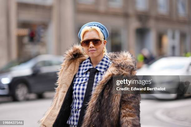 Guest wears a blue hat, golden earrings , brown fluffy faux fur oversized jacket , a black and white checkered / checked pattern printed shirt,...
