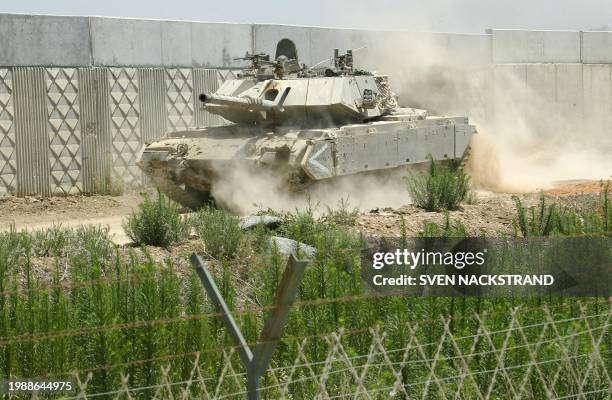 An Israeli tank patrols along a concrete wall that separate the Israeli village of Bat Hefer from the Palestinian town of Tulkarem 18 June 2002. This...