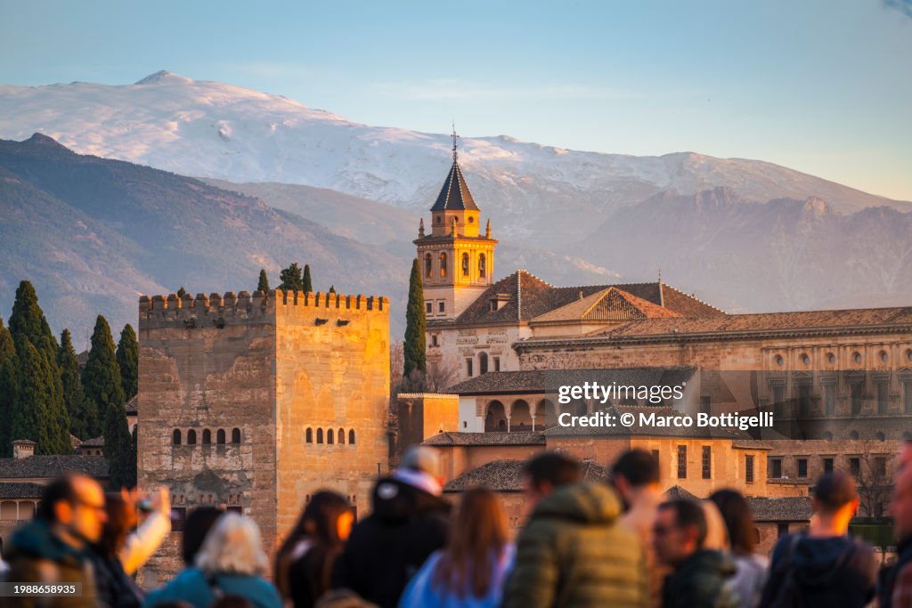 Tourists and the Alhambra at sunset, Granada, Spain