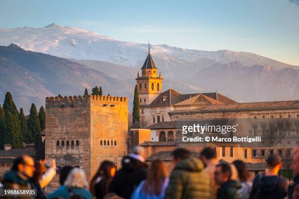 tourists and the alhambra at sunset, granada, spain - granada spain landmark stock pictures, royalty-free photos & images