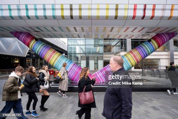 People interacting with the geometric public artwork 'Click Your Heels Together Three Times' by artist Adam Nathaniel Furman on the exterior of the...