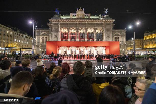 People react in front of the Vienna State Opera prior to the start of the this year's traditional Opera Ball on February 8, 2024. / Austria OUT